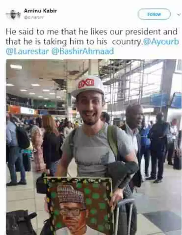" I Like Him ":- White Man Pictured With A Portrait Of Pres.Buhari At The Airport